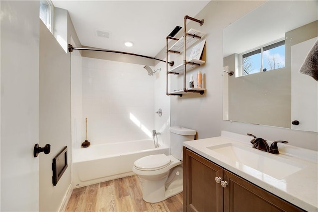 bathroom with toilet, wood finished floors, visible vents, vanity, and bathing tub / shower combination