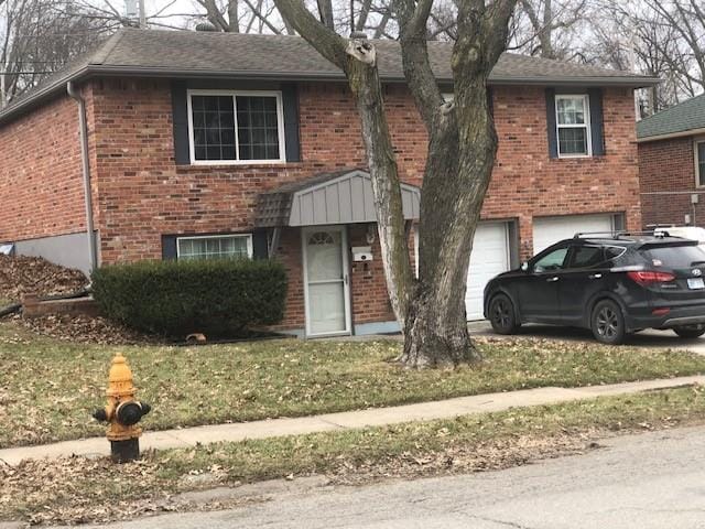 view of front facade featuring concrete driveway, brick siding, and an attached garage