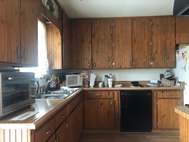 kitchen featuring light countertops, white appliances, a sink, and brown cabinets