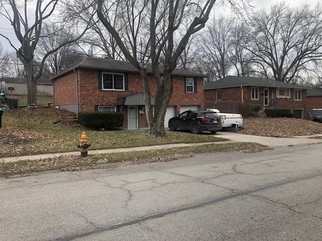 view of front facade with a garage, brick siding, and concrete driveway