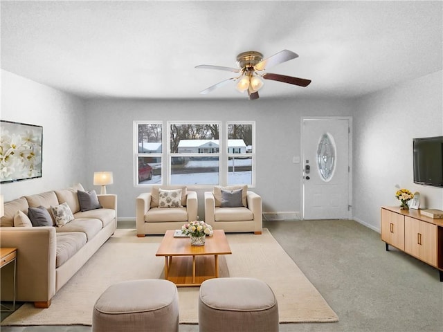 living room with a ceiling fan, light carpet, and baseboards