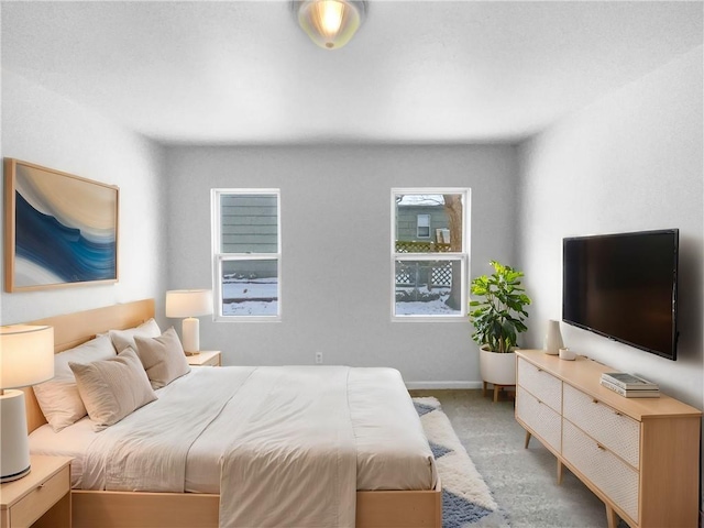 bedroom with carpet floors, multiple windows, and baseboards