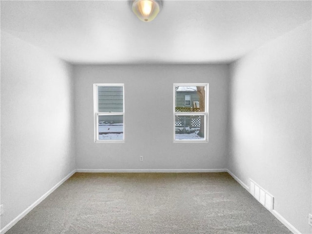 unfurnished room featuring baseboards, visible vents, and carpet flooring