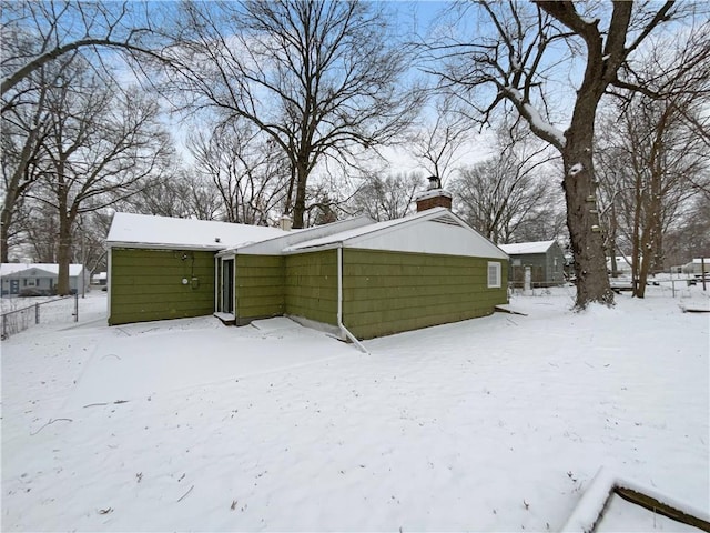 snow covered house with a chimney