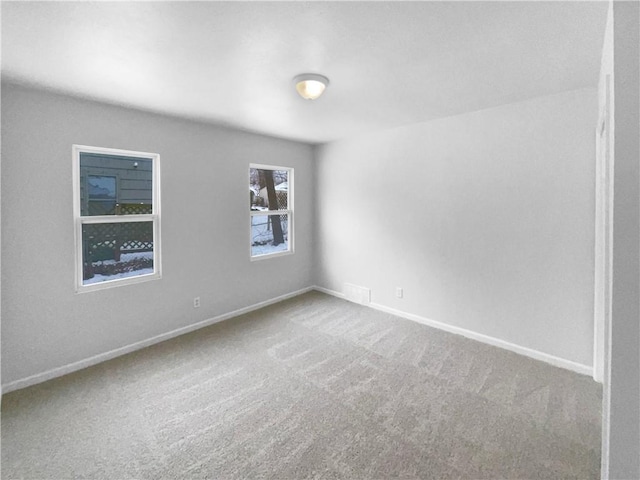 carpeted empty room with visible vents and baseboards