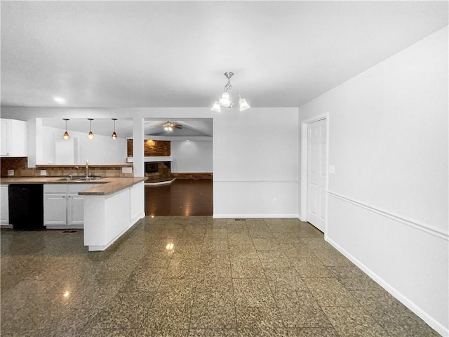 kitchen featuring baseboards, dishwasher, decorative light fixtures, white cabinetry, and a sink