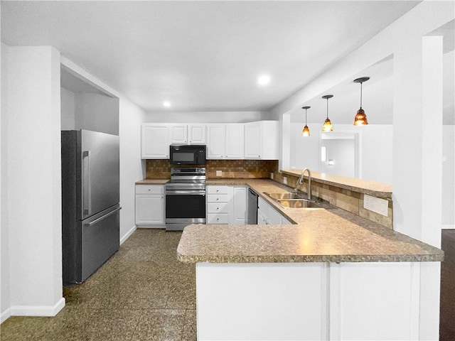 kitchen featuring backsplash, appliances with stainless steel finishes, a sink, a peninsula, and baseboards