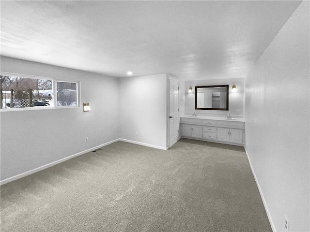 interior space featuring visible vents, connected bathroom, baseboards, and carpet flooring