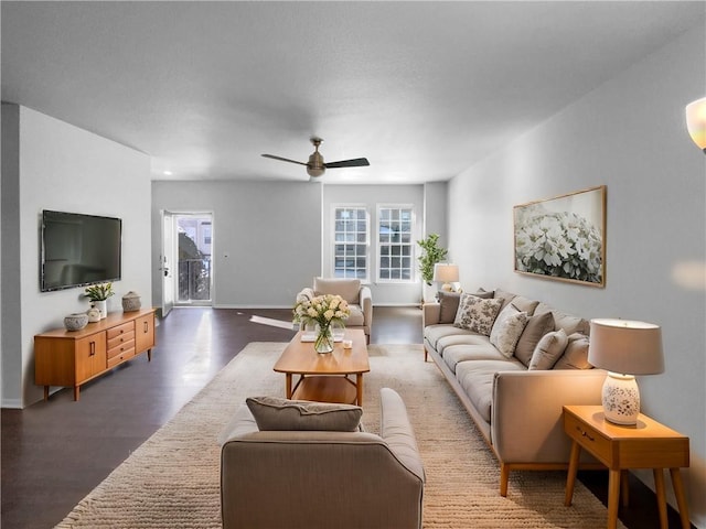 living area with plenty of natural light, baseboards, ceiling fan, and wood finished floors