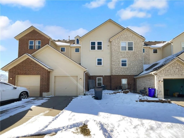 multi unit property with a garage and brick siding