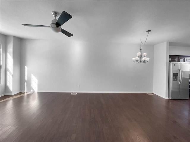 unfurnished living room featuring baseboards, dark wood-style flooring, and ceiling fan with notable chandelier