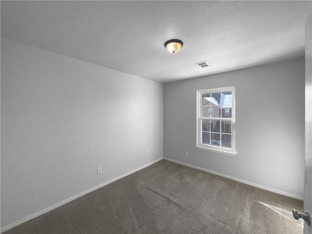 carpeted empty room featuring a textured ceiling, visible vents, and baseboards