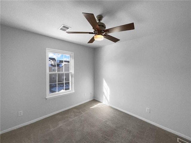 carpeted empty room featuring a healthy amount of sunlight, baseboards, and visible vents