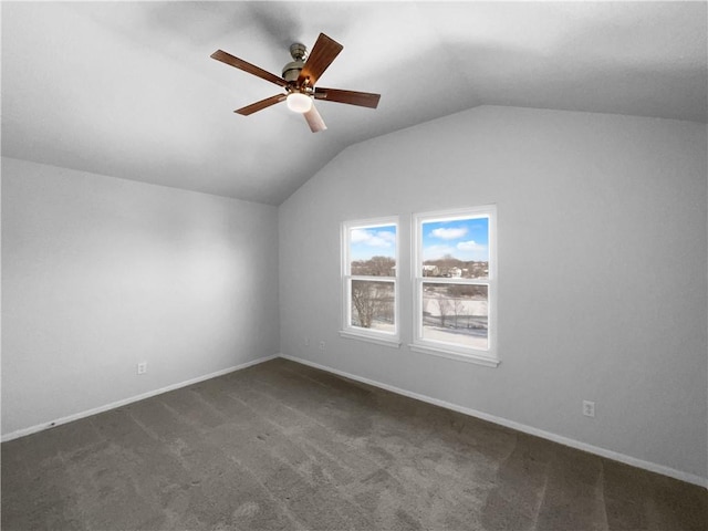 additional living space with vaulted ceiling, dark colored carpet, ceiling fan, and baseboards