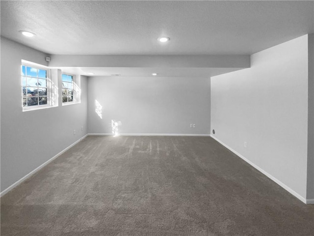 below grade area featuring a textured ceiling, carpet floors, recessed lighting, and baseboards