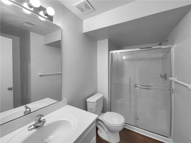 bathroom with toilet, a shower stall, visible vents, and vanity