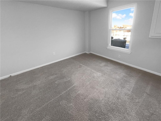 empty room featuring carpet floors and baseboards