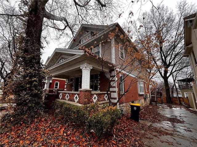 view of home's exterior featuring covered porch and brick siding