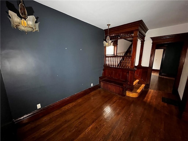 interior space with stairs, wood finished floors, baseboards, and an inviting chandelier