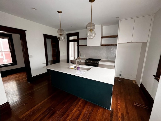 kitchen with white cabinets, range with gas stovetop, light countertops, open shelves, and a sink