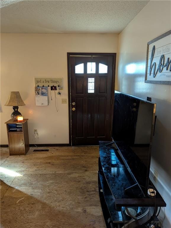 entrance foyer with baseboards and a textured ceiling