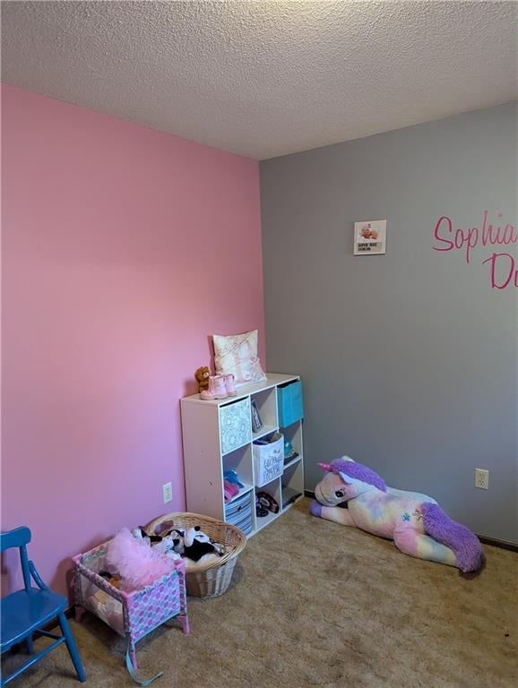 recreation room with a textured ceiling and carpet