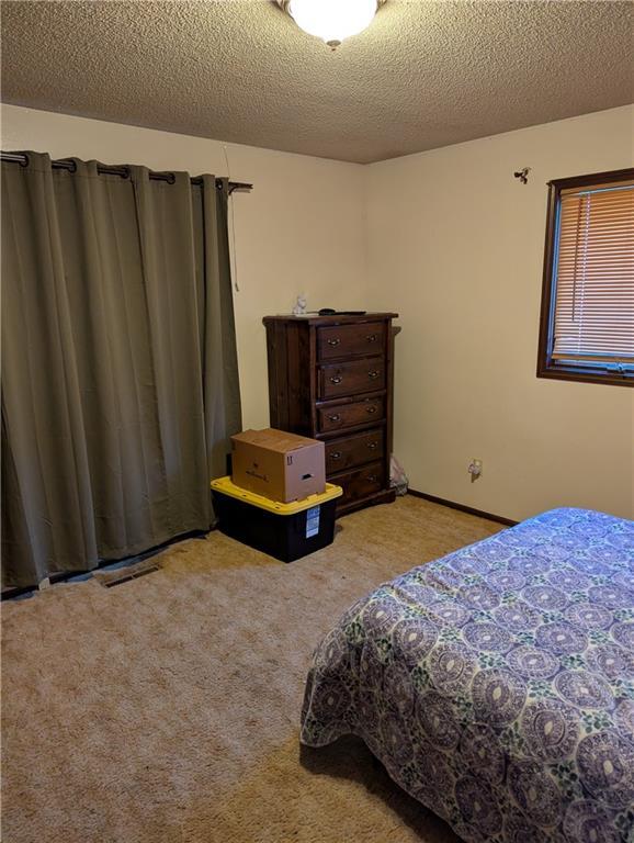 carpeted bedroom featuring visible vents and a textured ceiling