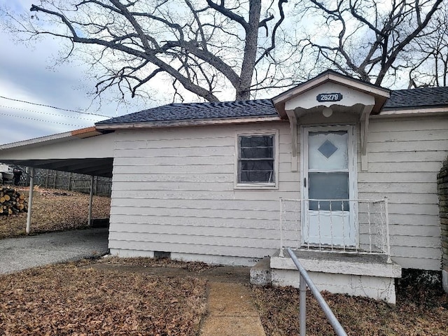 view of front of home with a shingled roof, an attached carport, crawl space, and driveway