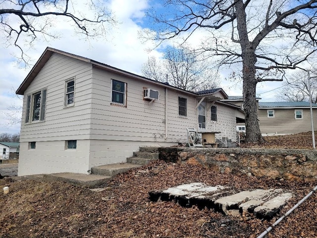 back of property with a wall mounted air conditioner