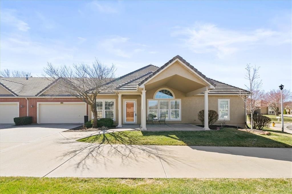 14549 Birch St, Leawood, KS 66224 - ranch-style house with a tiled roof, a front yard, stucco siding, a garage, and driveway