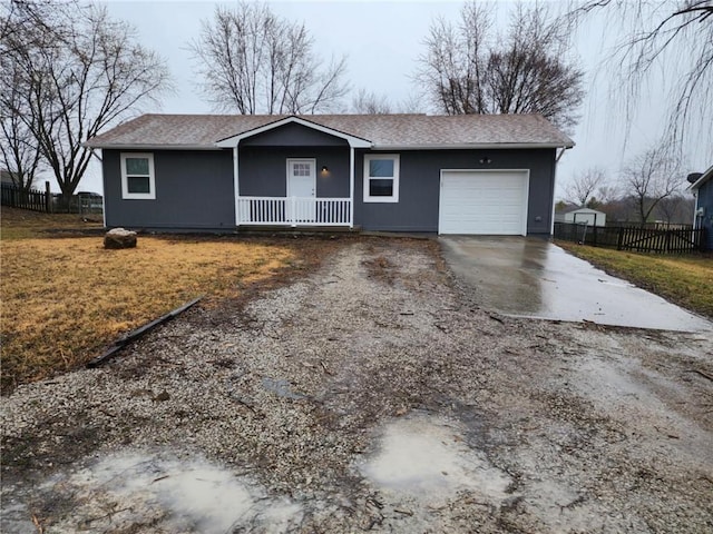 ranch-style house featuring driveway, an attached garage, covered porch, fence, and a front lawn