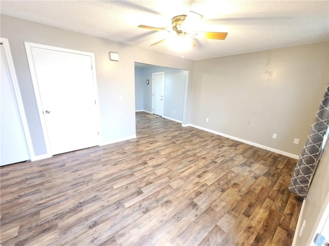 unfurnished room featuring a ceiling fan, a textured ceiling, baseboards, and wood finished floors