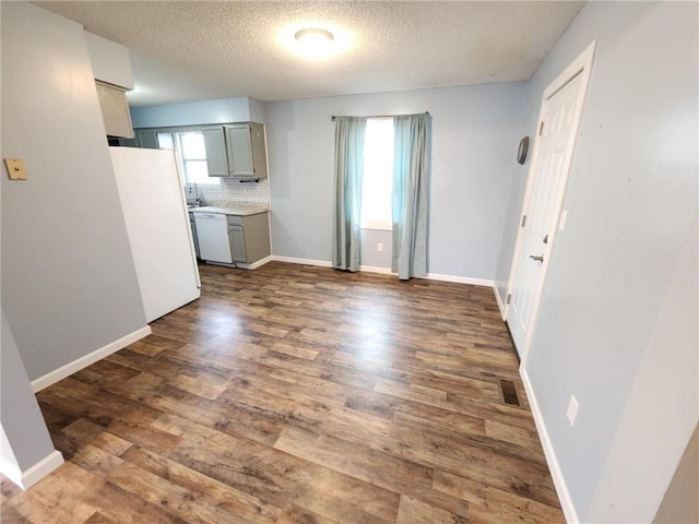 kitchen featuring white appliances, visible vents, gray cabinets, decorative backsplash, and dark wood finished floors