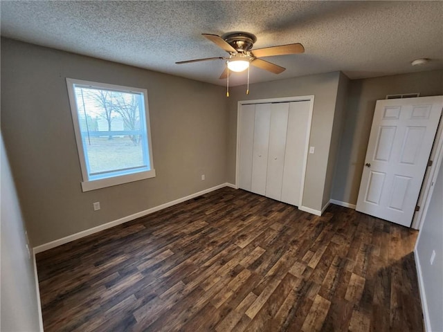 unfurnished bedroom with dark wood-style floors, baseboards, and a closet