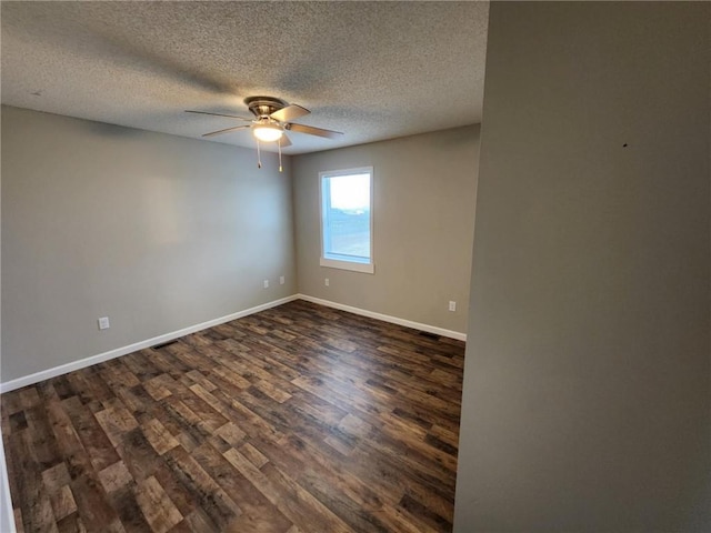 unfurnished room with ceiling fan, baseboards, dark wood finished floors, and a textured ceiling