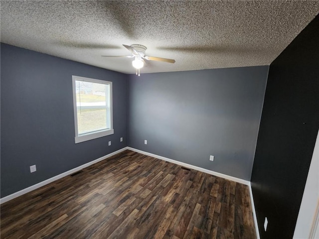 unfurnished room featuring a ceiling fan, dark wood-style flooring, visible vents, and baseboards