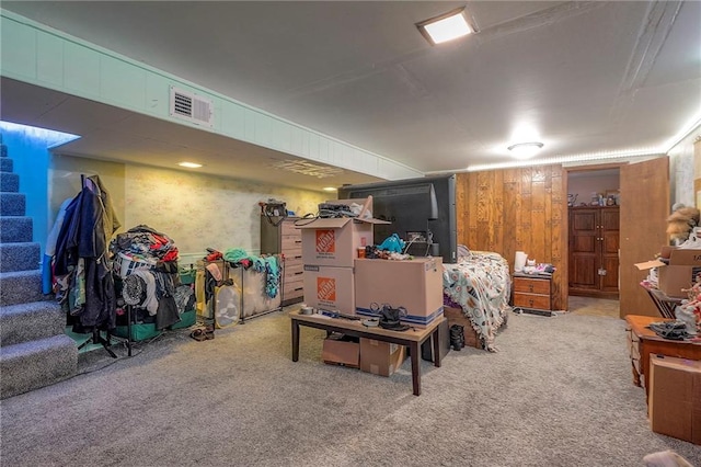 finished basement with visible vents, carpet flooring, and stairway