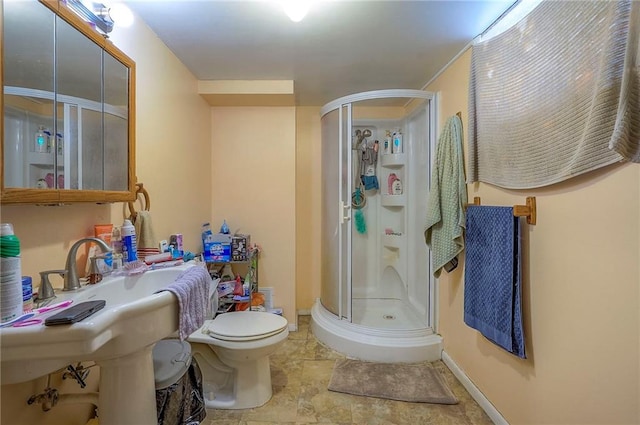 full bath featuring a shower stall, toilet, and baseboards