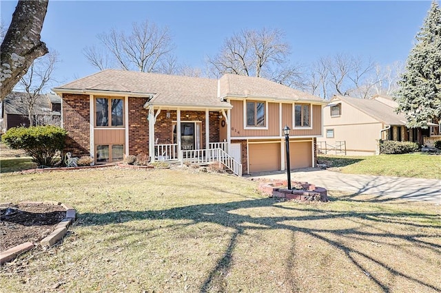 raised ranch with driveway, a porch, a front lawn, a garage, and brick siding