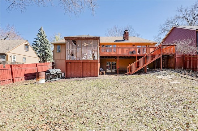 back of property with a fenced backyard, a chimney, a deck, and stairs