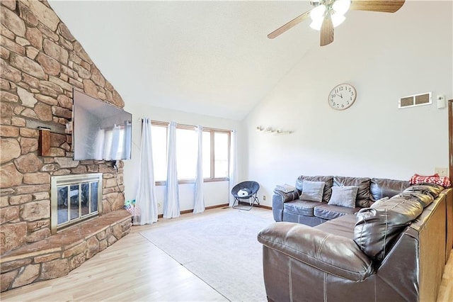 living area featuring visible vents, high vaulted ceiling, wood finished floors, a fireplace, and ceiling fan