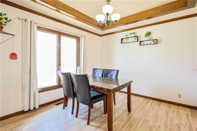 dining space with baseboards, light wood-type flooring, an inviting chandelier, and ornamental molding