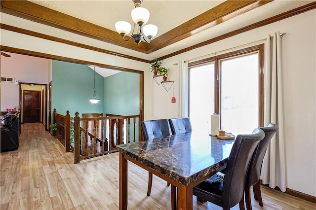 dining space with ornamental molding, visible vents, light wood-type flooring, and a chandelier