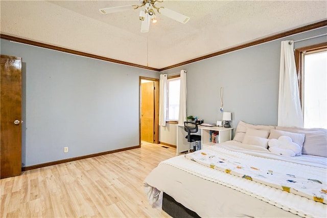 bedroom with baseboards, ceiling fan, light wood-style floors, a textured ceiling, and crown molding