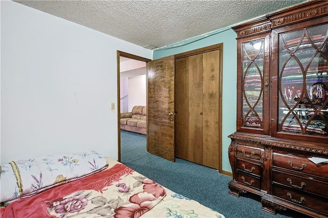 carpeted bedroom featuring a closet, a textured ceiling, and access to exterior