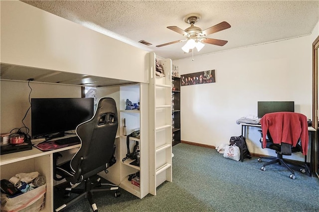 home office with visible vents, carpet floors, a textured ceiling, and ceiling fan