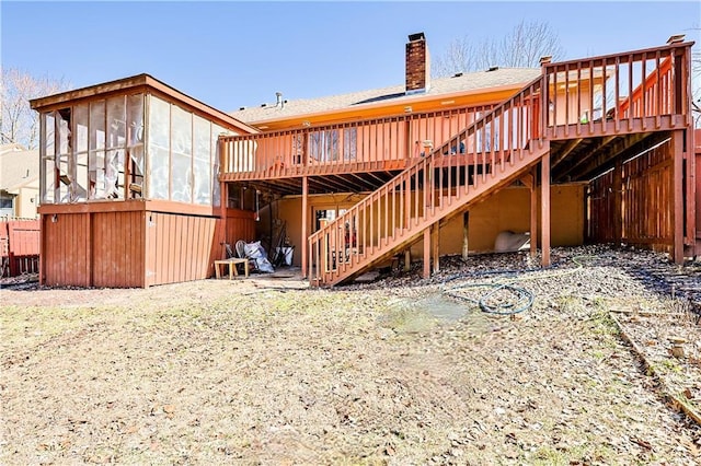 back of property featuring a wooden deck, a chimney, and stairs