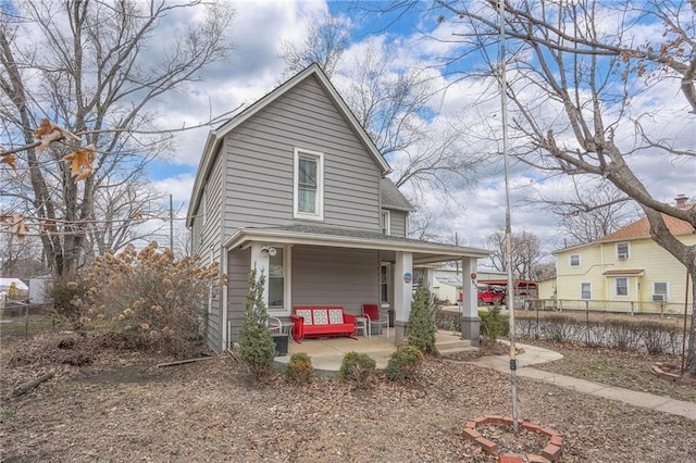 view of front of home featuring a porch, roof with shingles, and fence