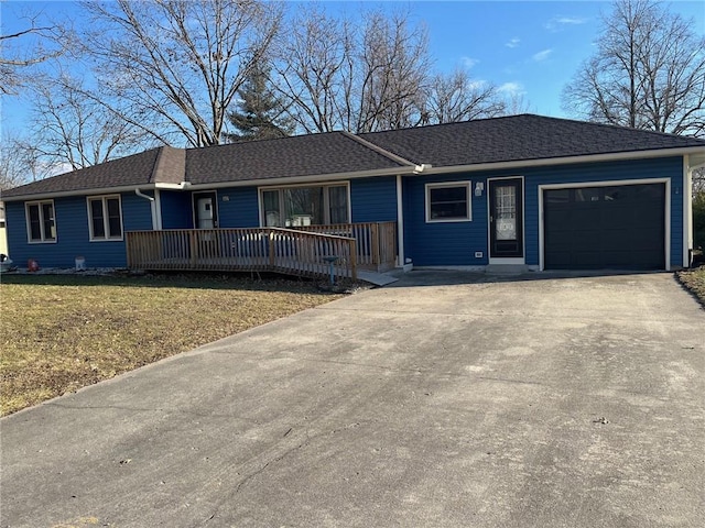 ranch-style house with a garage, driveway, a shingled roof, and a front lawn