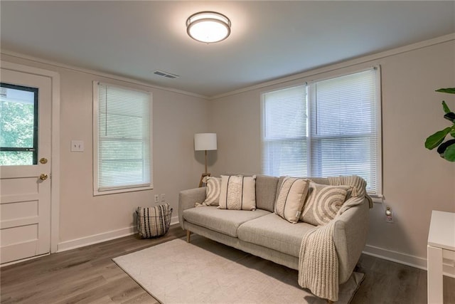 living area with baseboards, visible vents, and wood finished floors